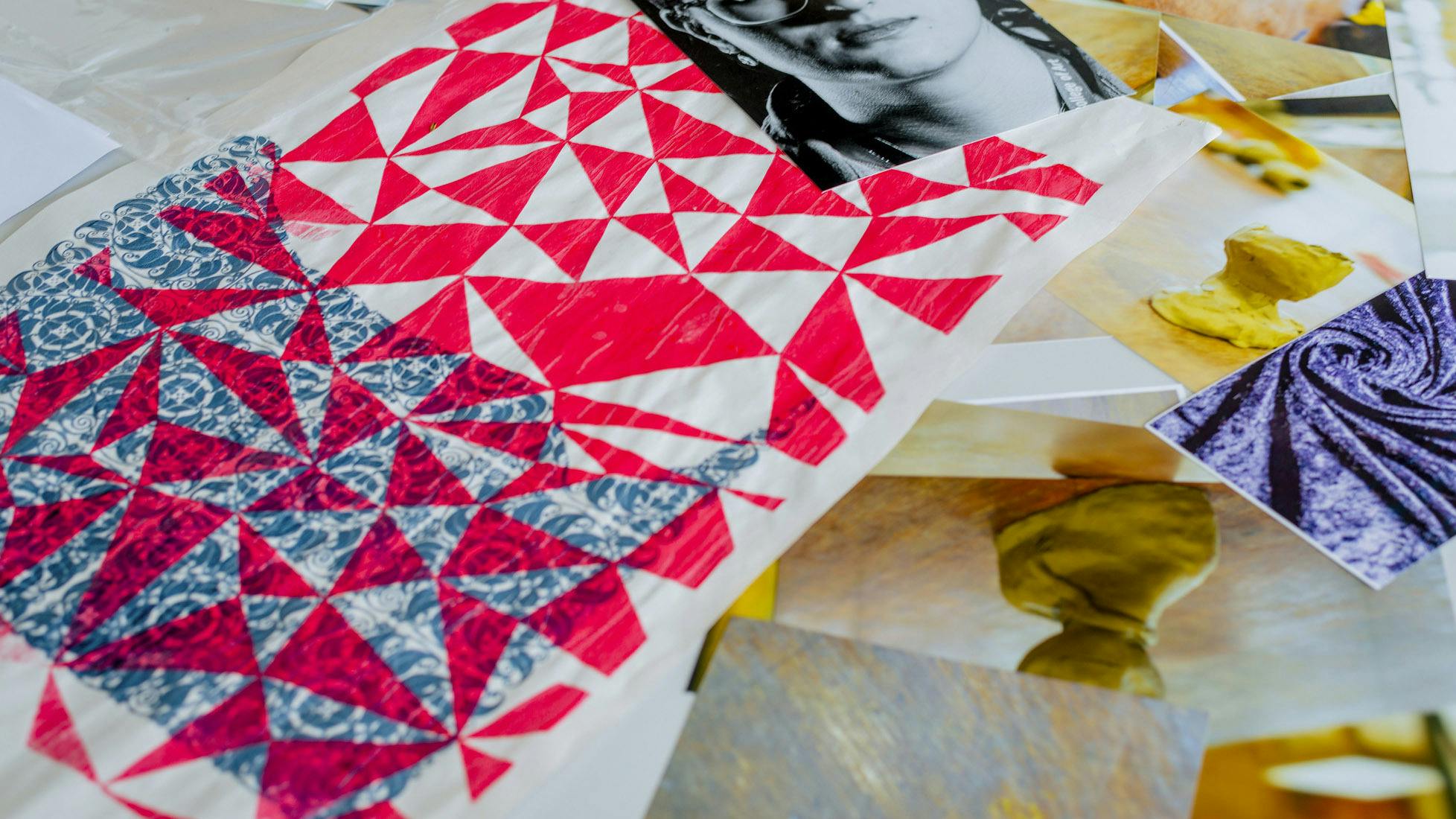 Brightly coloured bold graphic prints and photographs scattered across a table