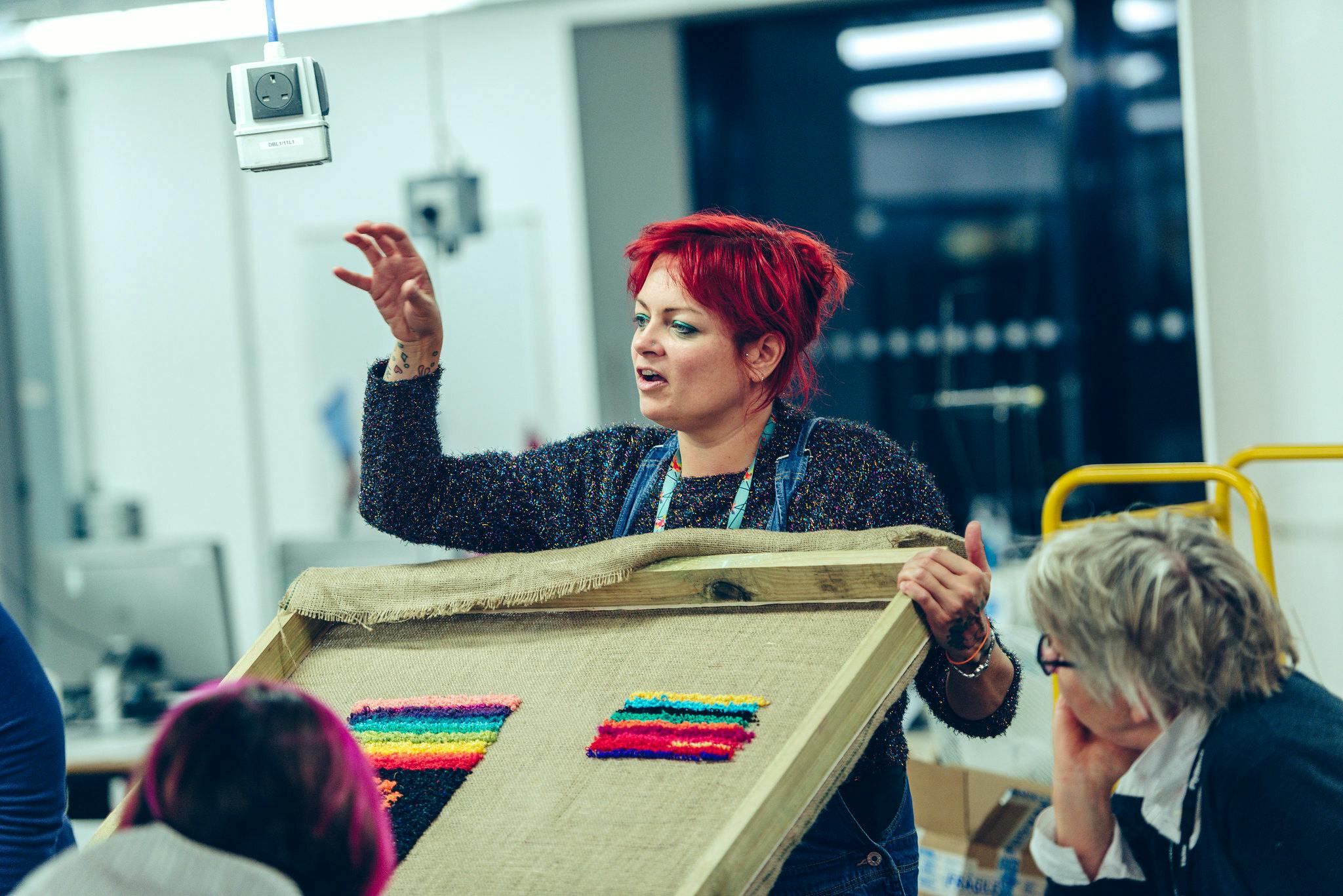 Lecturer Becky Dodman Wainwright teaching on the textile course showing tufting punch needle examples to a group