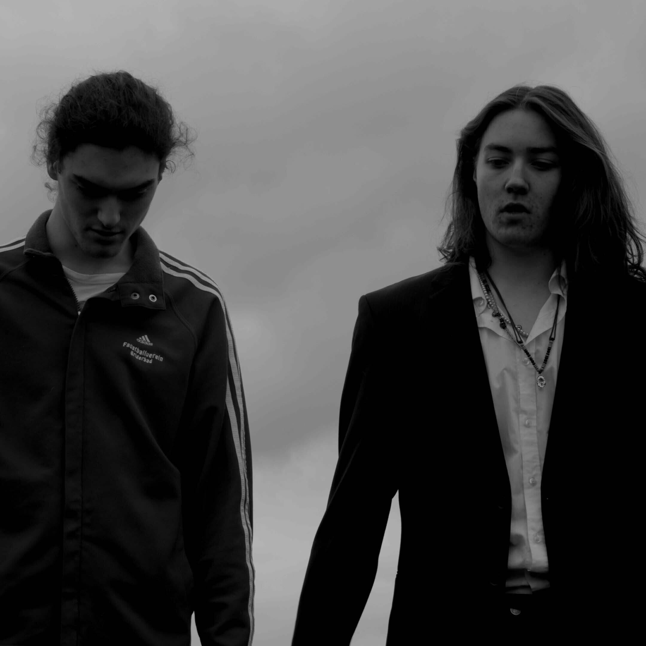 Black and white photo of two actors stood against a cloudy sky by 2022 BA Hons Film and Screen Arts graduate Jack Radford