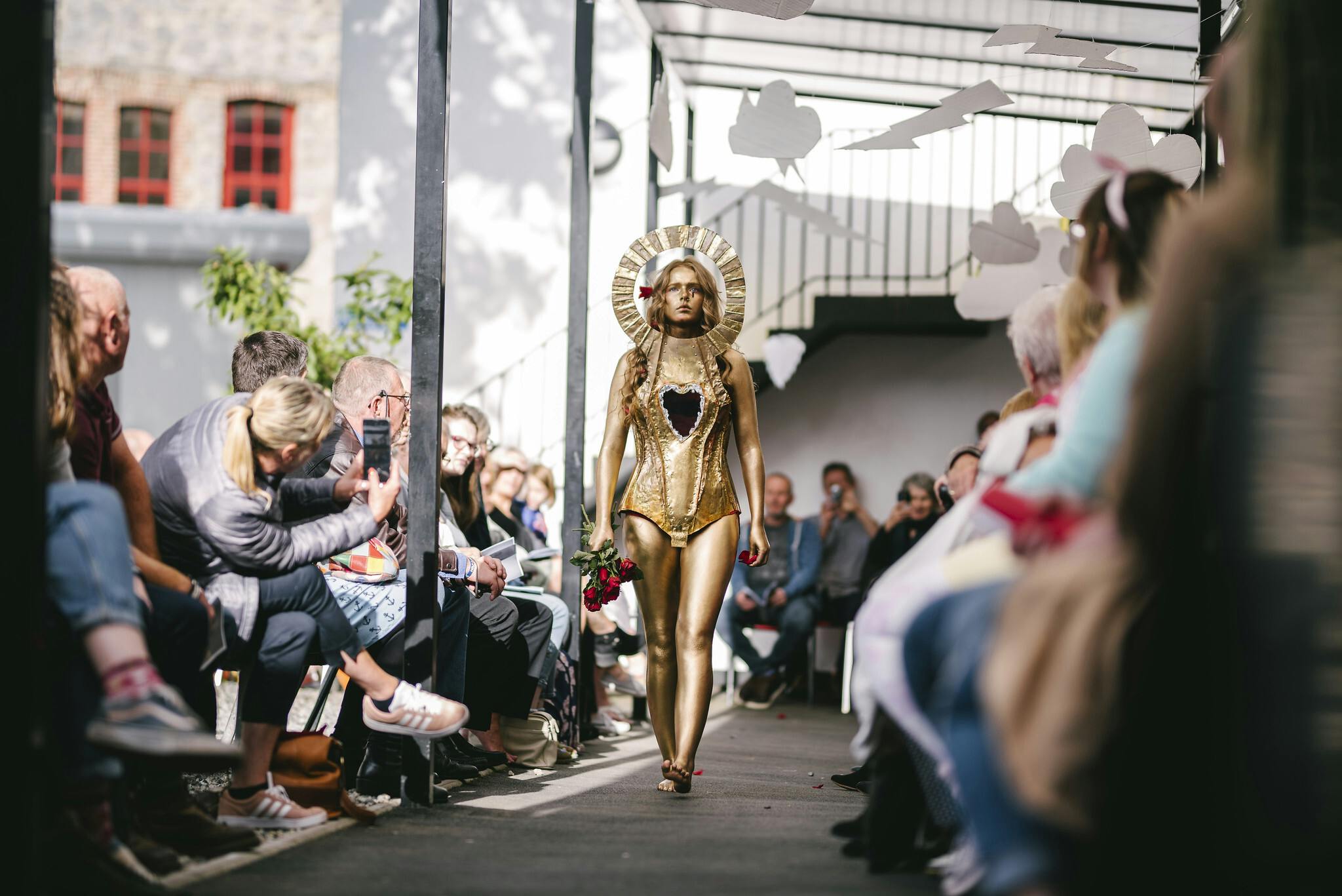 A model dressed in a gold outfit walks down the catwalk at Arts University Plymouths Pre degree Summer Show 2019 Photo by Luke Frost