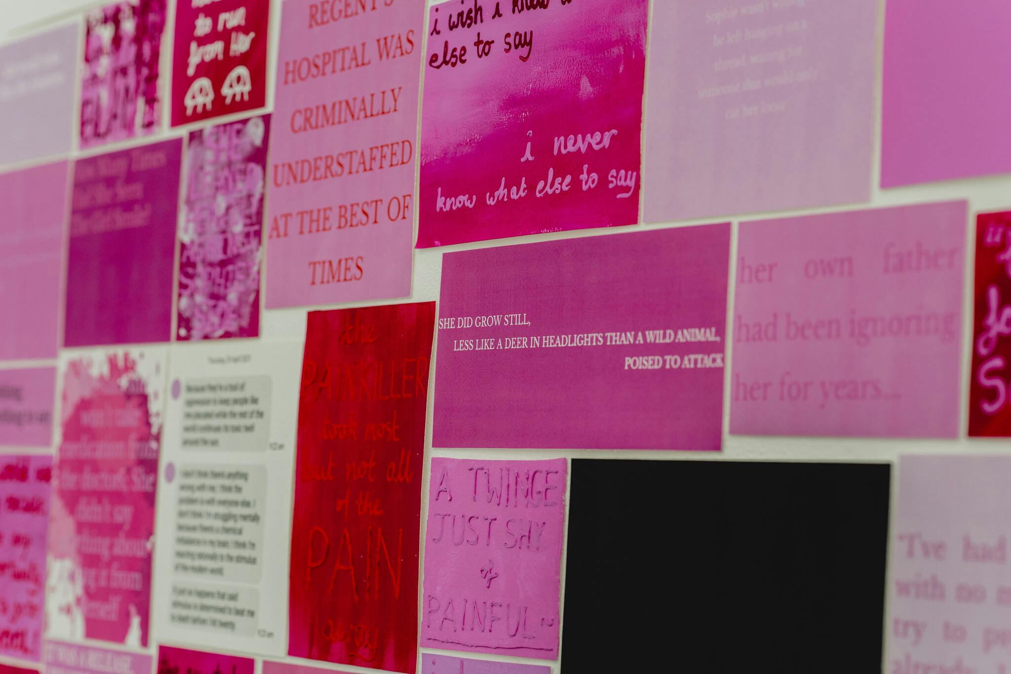 Plymouth College of Art Fine Art installation by E.J Willow featuring a wall of various shades of pink stickers, posters and quotes
