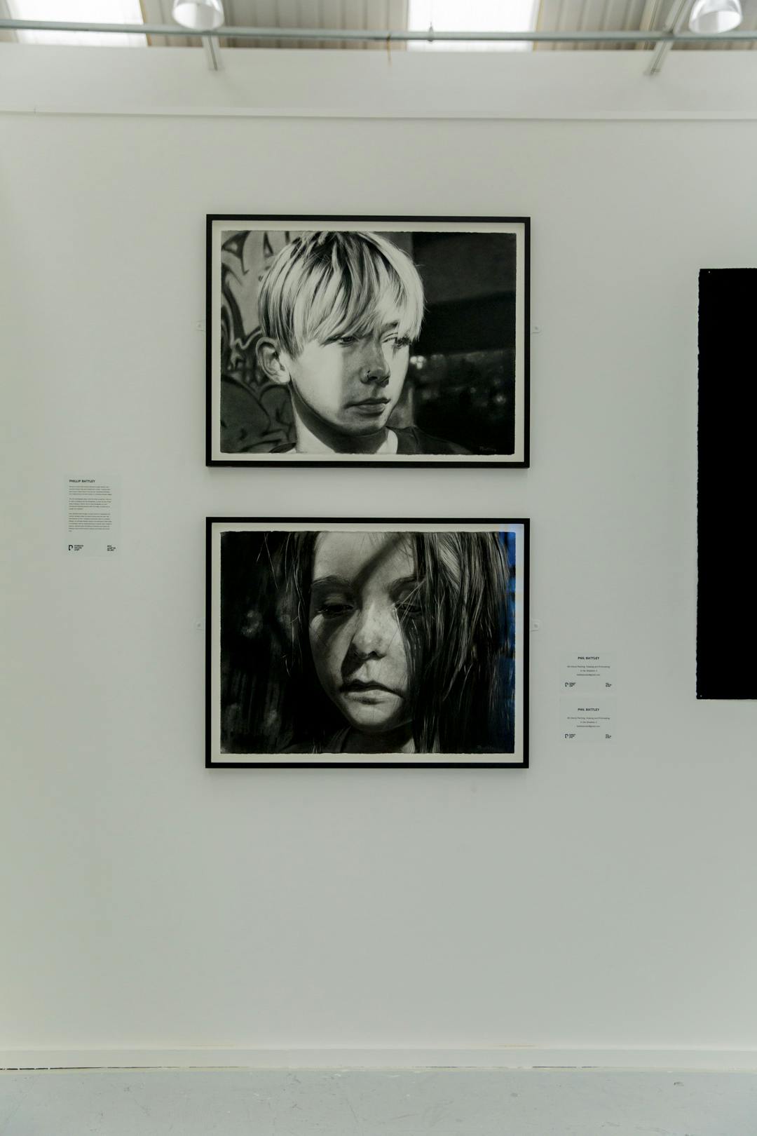 Image shows Phillip's hand drawn greyscale images featuring two children and shadowed light in black frames on a neutral background