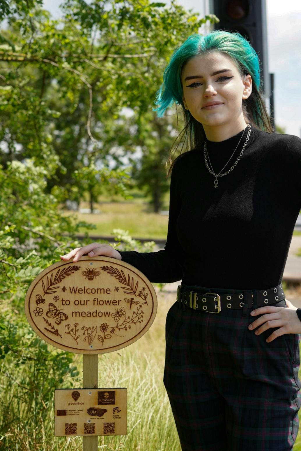 Lauren Williams with their wildflower meadow sign Image Credit Paul Williams