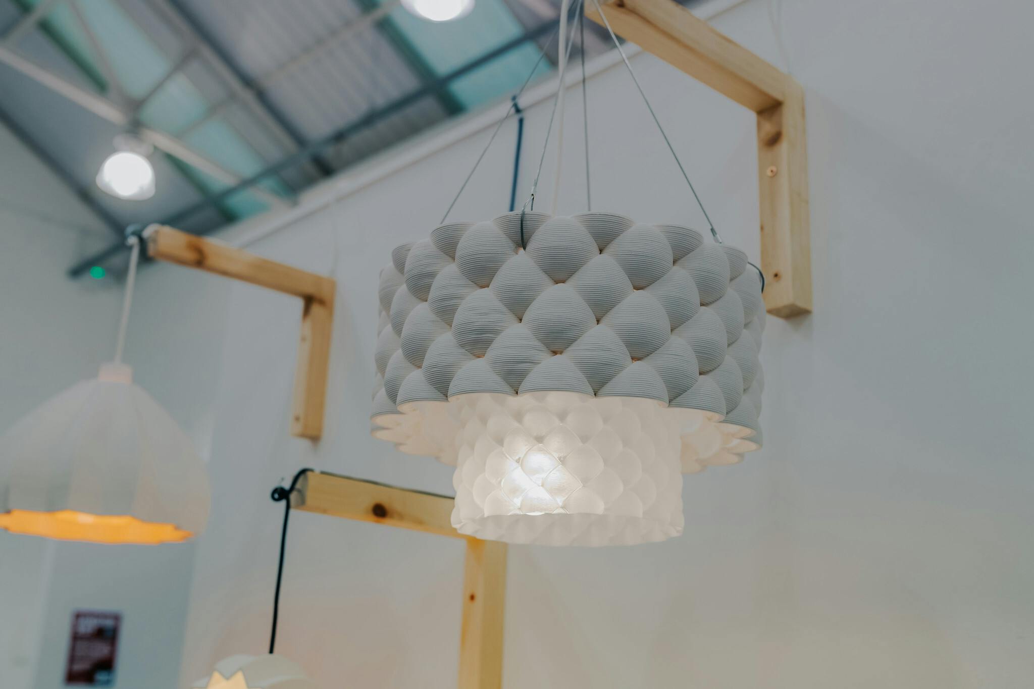 A soft white lampshade hanging from a wooden beam