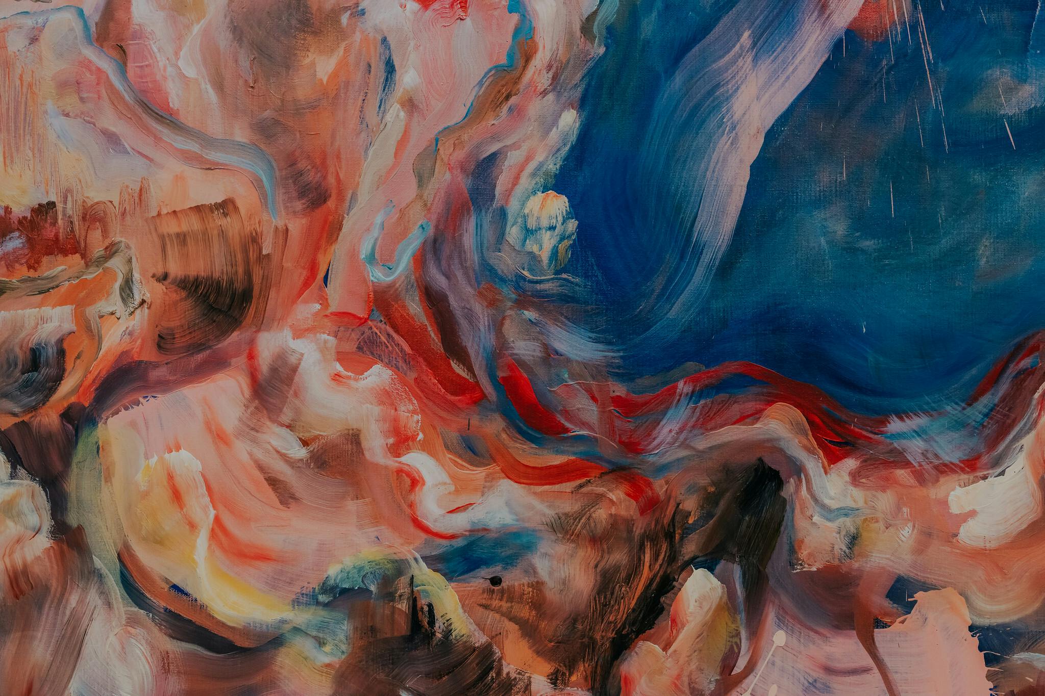 A close up of sprawling painted swirls in colours of peach and red and blue and white