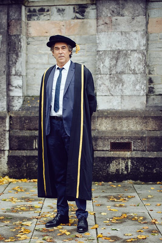 Arts University Plymouth Honorary Fellow Antoine Leperlier 2014 stands in front of an old building in graduation robes