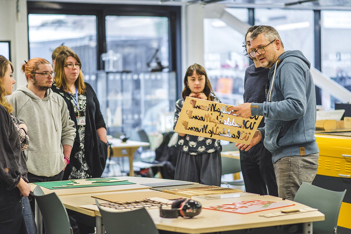 A man shows a group of students some examples of laser cutting in Plymouth College of Arts Fab Lab AYCH Digital Week January 2019